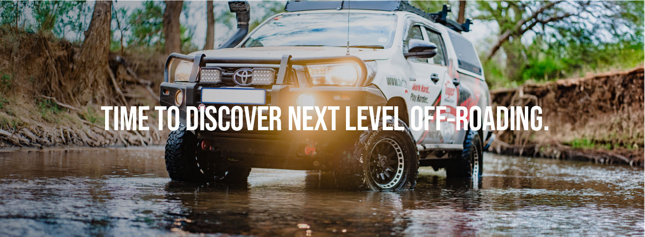 4x4 Fitment Centres Webpage banner: A kitted 4x4 vehicle driving through a stream.